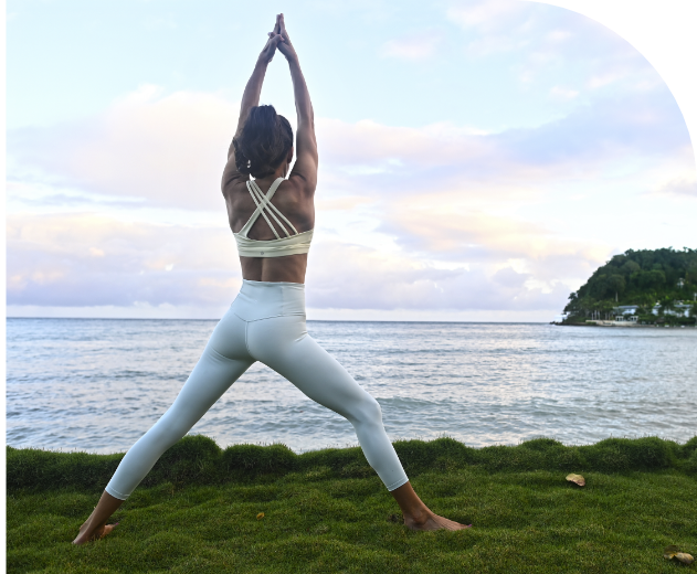 Guest practicing yoga beside the sea at Round Hill